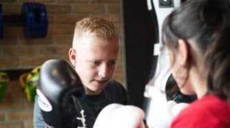 Kinderen trainen kickboksen met een trainer