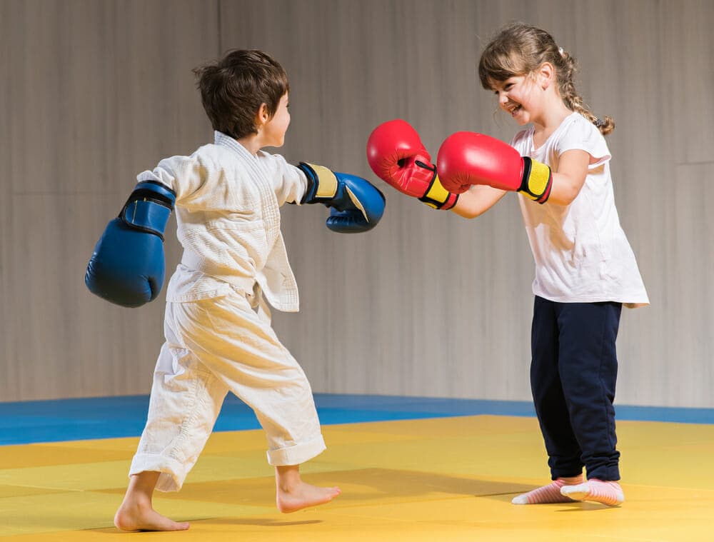 Twee kinderen met bokshandschoenen tijdens een kickbokstraining